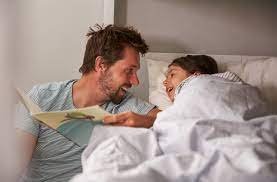 dad reading to child in bed
